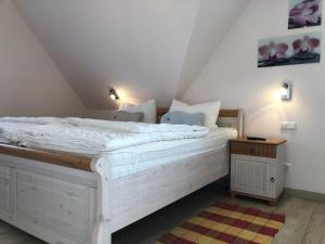 sypialnia z dużym białym łóżkiem na poddaszu w obiekcie Friedenstrasse Haus Kranich w Zingst