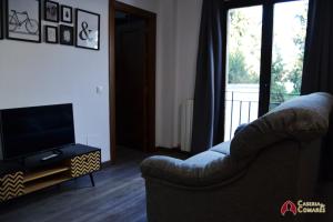 sala de estar con sofá y TV en Caseria de Comares 201, en Granada