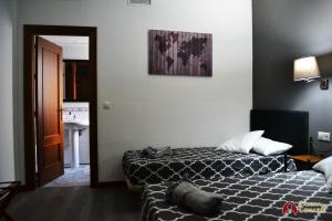 a hotel room with two beds and a bathroom at Caseria de Comares 201 in Granada