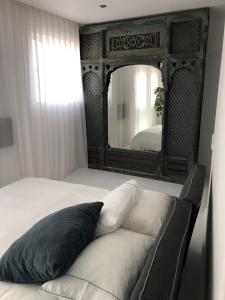 a bedroom with a bed with a large mirror at Portobello River and Sea View in Alvor