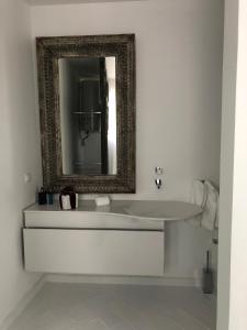 a bathroom with a white sink and a mirror at Portobello River and Sea View in Alvor