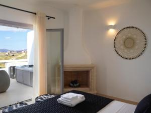 a bedroom with a bed with a fireplace and a window at Absolute Paradise Santorini in Akrotiri
