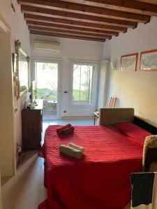 ein Schlafzimmer mit einem roten Bett mit einer roten Decke in der Unterkunft Beatiful modern flat Venice centre with private lounge green area relax in Venedig