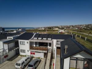 an aerial view of a house with cars parked in a parking lot at Kabeljauws Beach Apartments in Jeffreys Bay