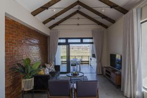 a living room with a brick wall at Kabeljauws Beach Apartments in Jeffreys Bay