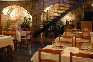 a restaurant with white tables and chairs and a staircase at Hotel Casa Carmen in Benabarre
