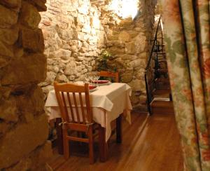 
a table and chairs in a room with a stone wall at Hotel Casa Carmen in Benabarre
