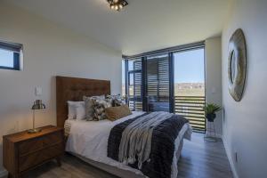 une chambre avec un lit et une grande fenêtre dans l'établissement Kabeljauws Beach Apartments, à Jeffreys Bay