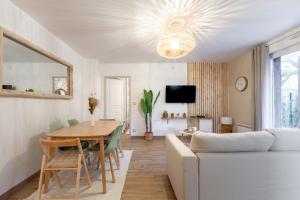 Una sala de estar con un sofá blanco y una mesa. en La Bohème, en Montévrain