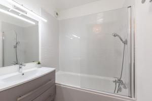 y baño blanco con ducha, lavabo y bañera. en La Bohème, en Montévrain 16 fotos más
