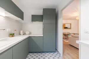 a kitchen with blue cabinets and a living room at La Bohème in Montévrain