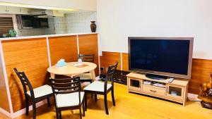 uma sala de estar com uma mesa e uma televisão em 田町ハウス em Takamatsu
