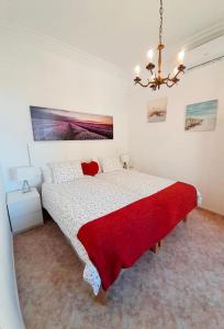 a bedroom with a large bed with a red blanket at Casa El Rafal in Porreres