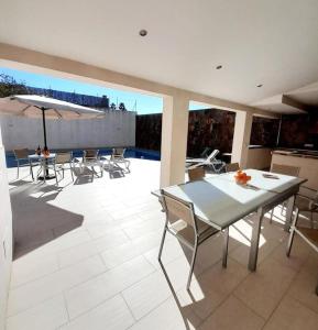 a patio with a table and chairs and an umbrella at Casa El Rafal in Porreres