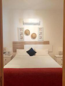 a bedroom with a large white bed with a red blanket at Casa El Rafal in Porreres