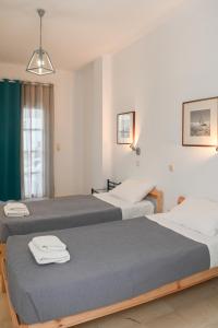 two beds in a hotel room with towels on them at Oscar Hotel in Kamari