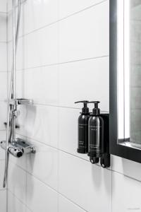 a bathroom with two bottles on a wall next to a mirror at First Camp Moraparken Hotel in Mora