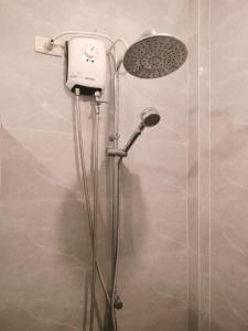 a shower with a shower head in a bathroom at Bais City Home Staycation in Bais