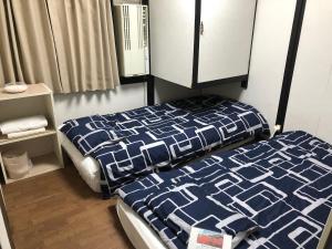 a bedroom with a bed with a blue and white comforter at KYOTO Guest House in Kyoto