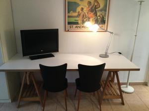 Televízia a/alebo spoločenská miestnosť v ubytovaní Studio fond de jardin