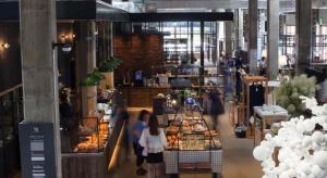 a group of people walking inside of a bakery at Hotel Cycle in Onomichi