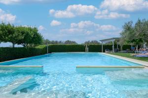 una grande piscina con acqua blu in un cortile di Hotel Montecallini - Adult Only 14 a Patù