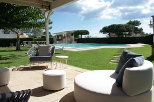 eine Terrasse mit einem Sofa, Stühlen und einem Pool in der Unterkunft Hotel Montecallini - Adult Only 14 in Patù