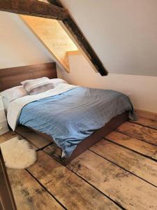 a bedroom with a bed with a wooden floor at Om chalet 1 avec spa face au fleuve in Saint-Jean