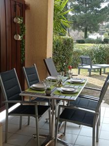 une table et des chaises sur une terrasse avec une table et des chaises dans l'établissement Cap Esterel Rez de jardin D2, à Saint-Raphaël