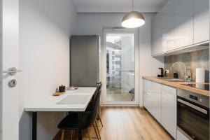 a kitchen with white cabinets and a table and chairs at Lwowska Apartment by the Malta Lake Poznań by Renters in Poznań