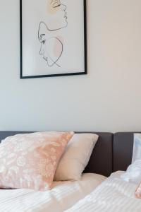 a bedroom with a bed with two framed pictures on the wall at Lwowska Apartment by the Malta Lake Poznań by Renters in Poznań
