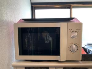 a microwave oven sitting on top of a table at KYOTO Guest House in Kyoto