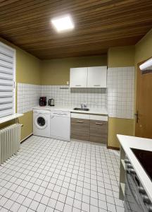 a kitchen with a washing machine and a tiled floor at 4-Zimmer Wohnung in Wuppertal 6 Personen in Wuppertal