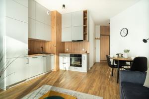 a kitchen and dining room with white cabinets and a table at ApartamentySnu, Struga Tower Deep Purple in Radom