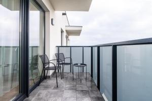 - un balcon avec des chaises et des tables dans un bâtiment dans l'établissement ApartamentySnu, Struga Tower Deep Purple, à Radom