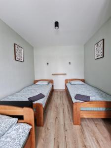 Apartamenti Jēkabpilī في جيكاببيلس: سريرين توأم في غرفة ذات أرضيات خشبية