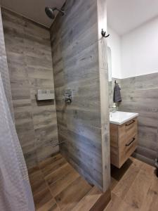 uma casa de banho com um chuveiro e uma parede de madeira em Apartamenti Jēkabpilī em Jēkabpils