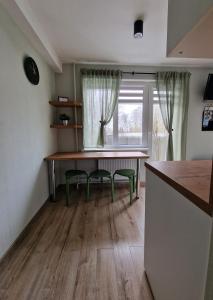 uma cozinha com uma mesa e duas cadeiras e uma janela em Apartamenti Jēkabpilī em Jēkabpils