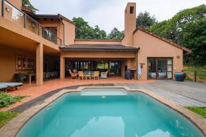 una piscina frente a una casa en San Lameer Villa 5910 - 4 Bedroom Luxury - 8 pax - San Lameer Rental Agency, en Southbroom