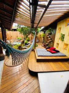 a porch with a hammock on a deck with a garden at Beco Pousada Boutique in Fernando de Noronha
