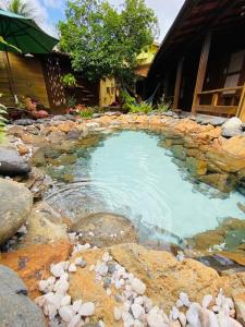 a large pool of water with rocks in front of a house at Beco Pousada Boutique in Fernando de Noronha