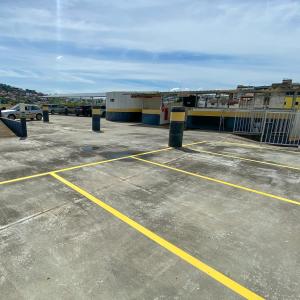 a parking lot with yellow lines in a parking lot at Elite Flat in Pará de Minas