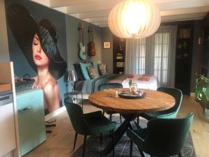 una habitación con una mesa con una mujer pintada en la pared en B&B De Kamer, en Wervershoof