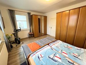 ケルピンセにあるFerienwohnung Koelpinsee USE 2464のベッドルーム1室(ベッド1台付)、木製キャビネットが備わります。
