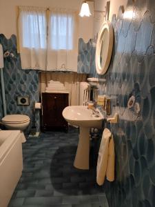 a bathroom with a sink and a toilet and a mirror at CASA GENTILINI in Dozza
