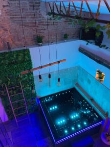 a hot tub in a room with blue lights at Love House "L'évasion Secrète" in Rivesaltes