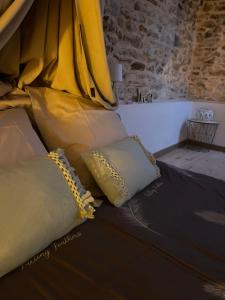 a couch with yellow curtains and pillows on it at Love House "L'évasion Secrète" in Rivesaltes
