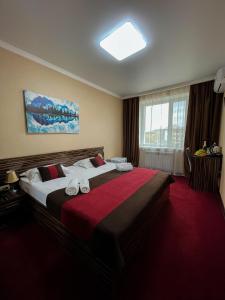 ein Hotelzimmer mit einem großen Bett mit Handtüchern darauf in der Unterkunft Premier Inn Astana in Astana