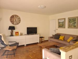uma sala de estar com um sofá e um relógio na parede em Appartamento Mont Fleury em Valtournenche