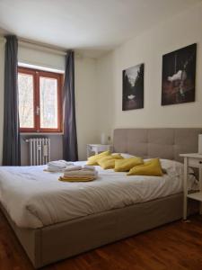 um quarto com uma cama grande e almofadas amarelas em Appartamento Mont Fleury em Valtournenche